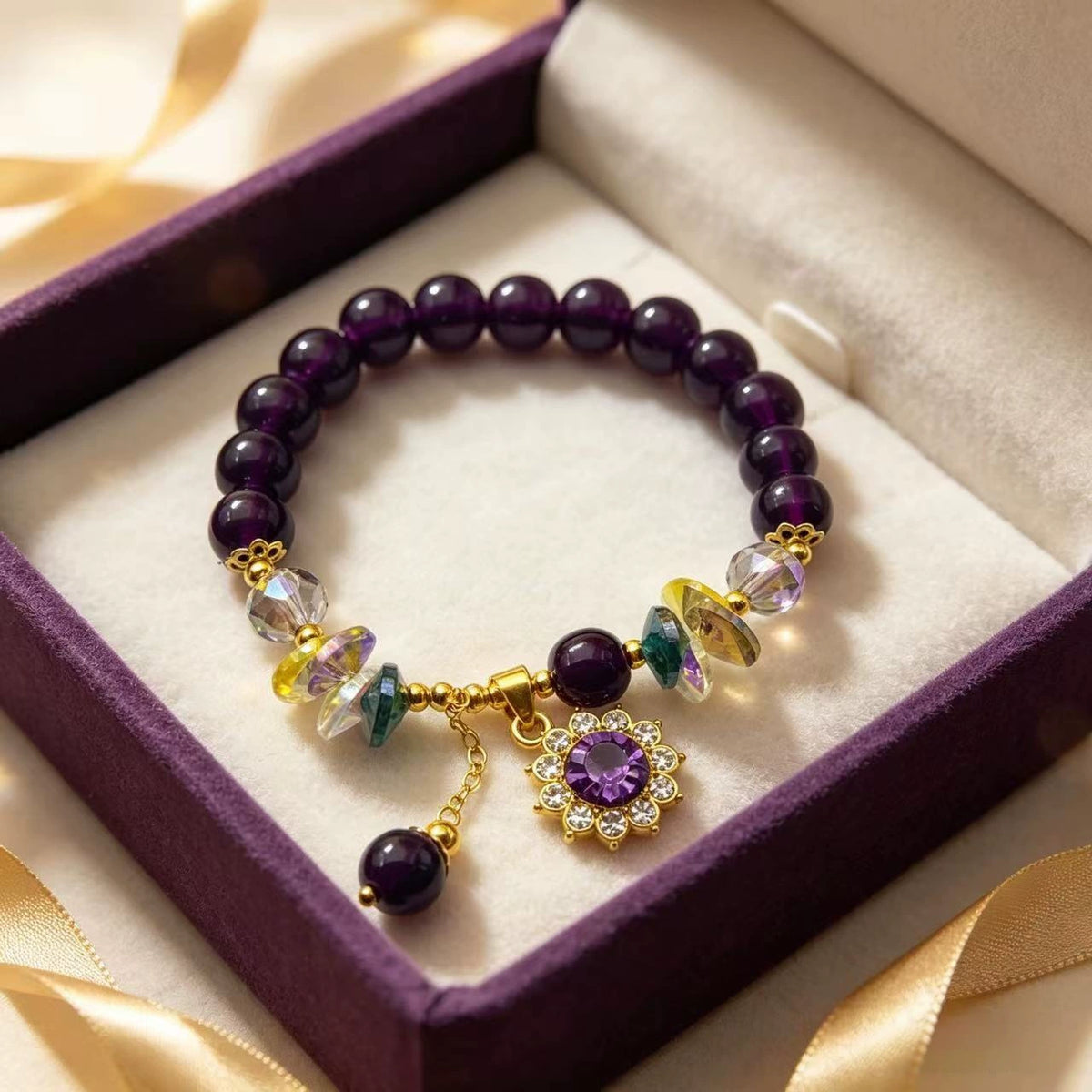Amethyst bead bracelet with a purple flower charm displayed in an open purple jewelry box.